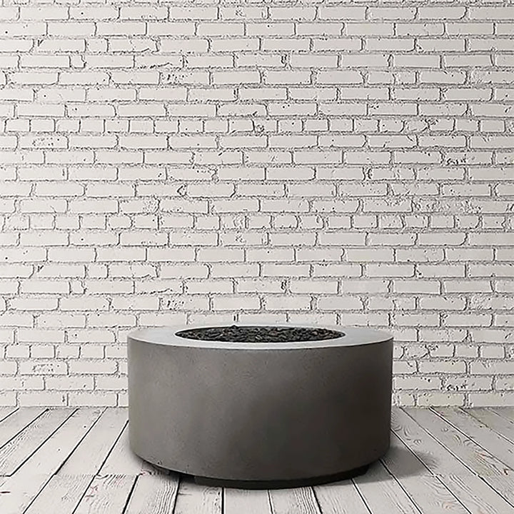 Prism Hardscapes Cilindro Gas Fire Pit in Pewter Light Gray, shown in a studio environment. Its round, minimalist design makes it ideal for modern fire pits and outdoor gas fire pits. This fire pit offers both style and functionality for backyard and patio spaces, providing warmth and a sleek aesthetic.