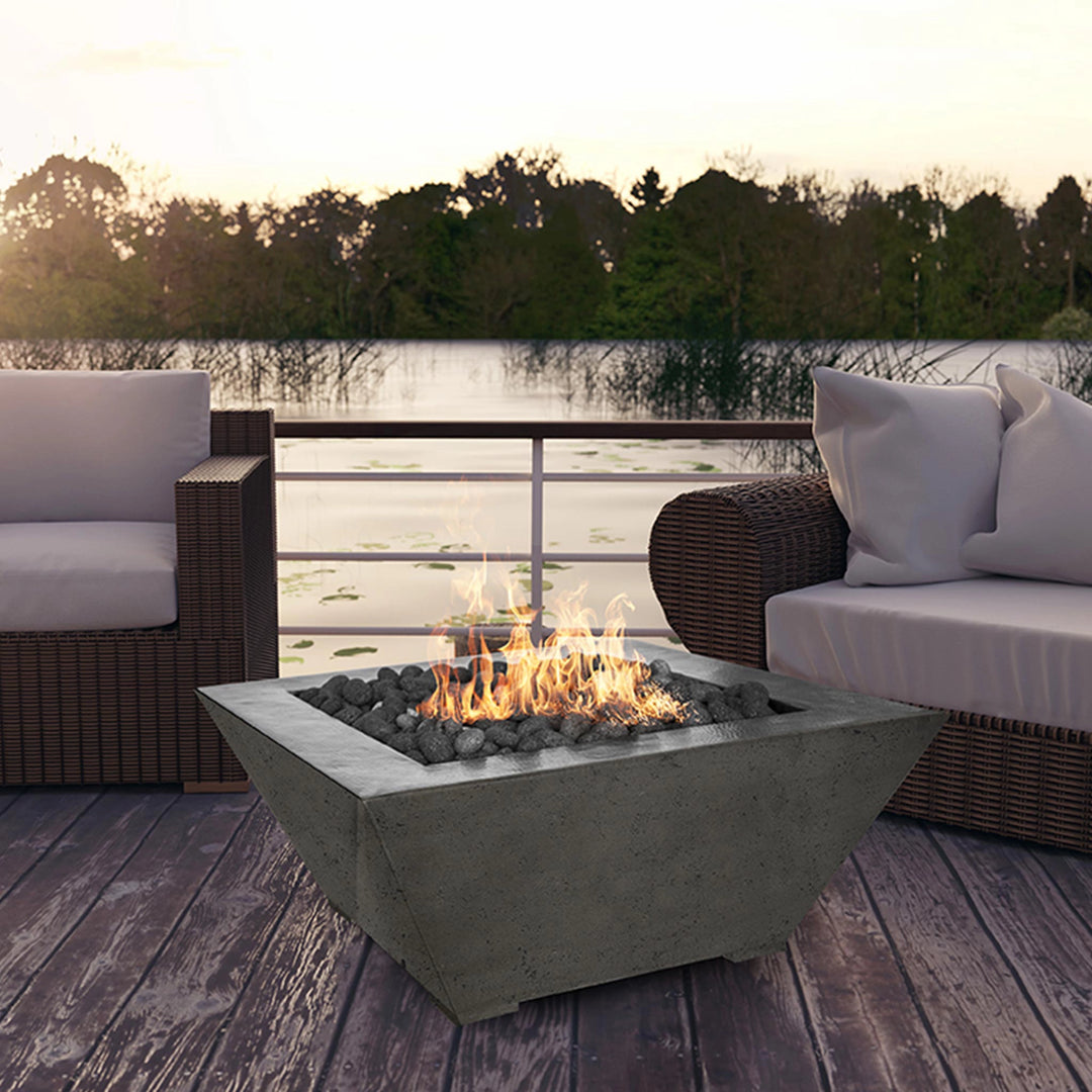  The Prism Hardscapes Lombard Gas Fire Pit in natural finish is set beautifully on a lakeside patio, creating a cozy outdoor setting. This square-shaped concrete fire pit enhances the aesthetic of a modern outdoor space, providing warmth and ambiance. Ideal for outdoor patios, this gas fire pit is perfect for use in backyards, poolside, or other outdoor areas. Featuring a powerful burner for optimal flame height, it's a stylish and functional addition to any contemporary setting. 