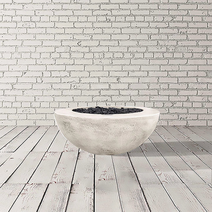 Prism Hardscapes Moderno 5 Gas Fire Pit in Natural Gray, presenting a light gray round concrete fire bowl. This outdoor fire pit delivers style and functionality, designed for both natural gas and propane fuel types. It's perfect for enhancing outdoor spaces with a modern touch while providing warmth and atmosphere. A great addition to patios and gardens, this fire pit is built for durability and outdoor enjoyment.