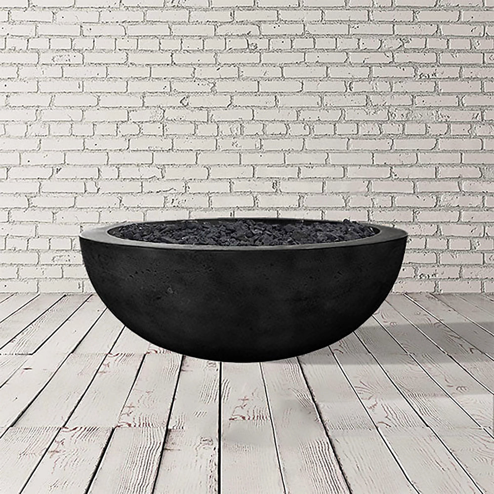 The Prism Hardscapes Moderno 4 Gas Fire Bowl in Ebony finish is presented in a studio setting, showcasing its sleek, dark concrete surface. This round gas fire pit offers a modern aesthetic, ideal for outdoor spaces seeking contemporary fire pits with a luxurious touch. Crafted from durable concrete, this fire bowl supports both natural gas and propane, making it a flexible choice for patios and backyard designs. The deep black color enhances its striking presence, creating a beautiful centerpiece for outdo