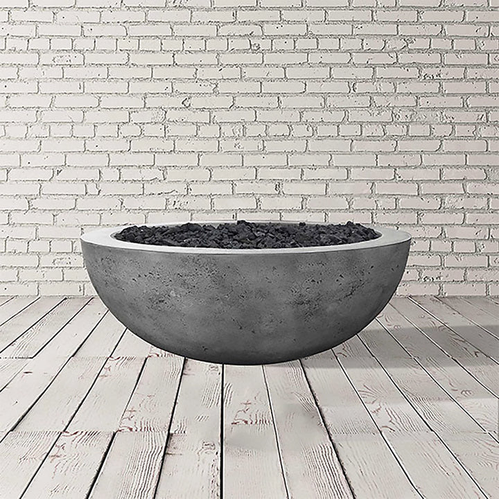 The Prism Hardscapes Moderno 4 Gas Fire Bowl in Pewter finish is highlighted in a studio shot, displaying its smooth, light gray concrete surface. As an outdoor gas fire pit, it provides a modern look with its round shape and refined texture, suitable for both residential and commercial spaces. Designed for use with propane or natural gas, this fire bowl serves as a striking focal point for any outdoor patio or backyard. It’s ideal for adding warmth and ambiance, especially when paired with black lava rock 