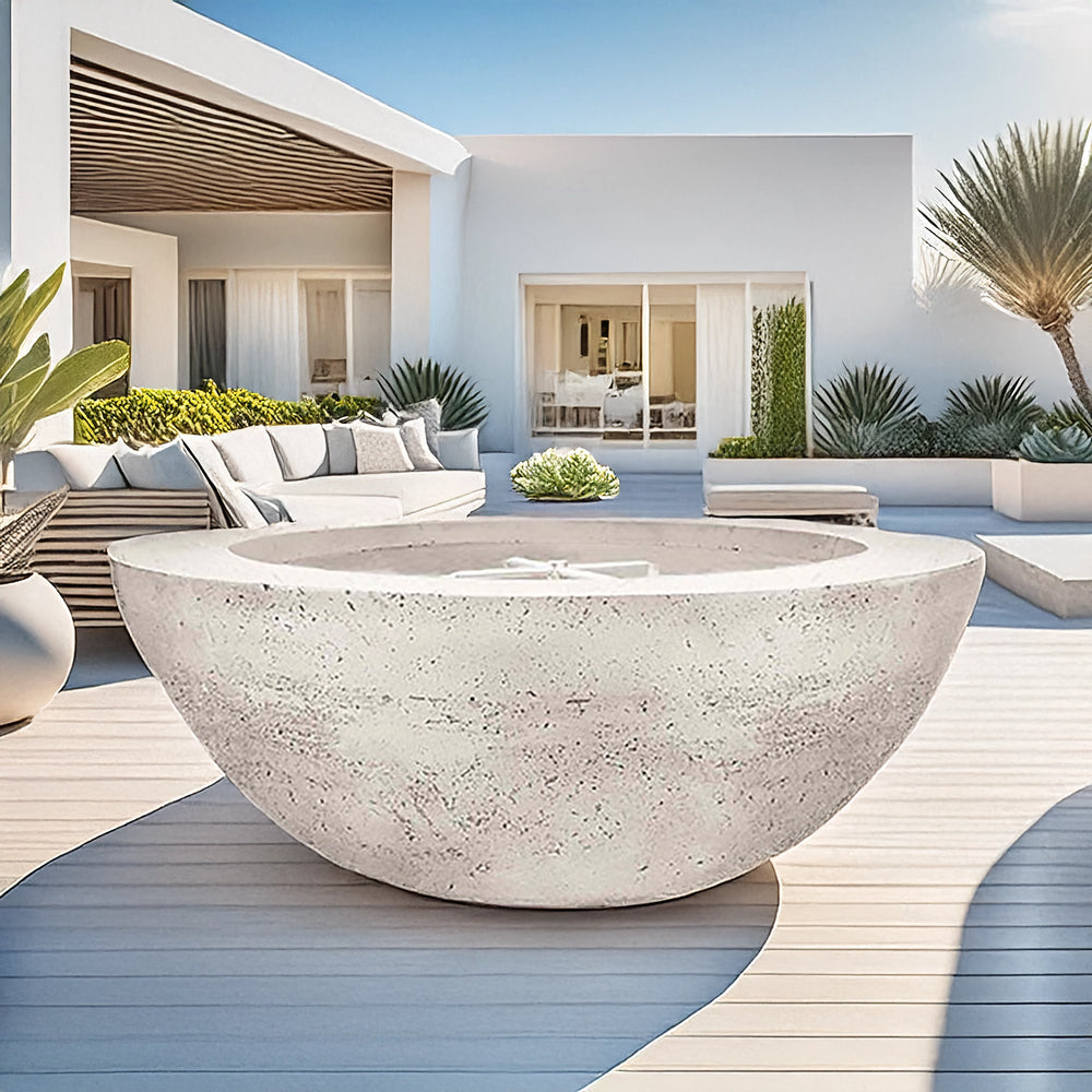 Prism Hardscapes Moderno 6 Gas Fire Pit in Ultra White, beautifully displayed in a luxurious, modern outdoor patio setting. This fire bowl adds a striking focal point to the clean, minimalist design of the space, blending seamlessly with the sleek white furniture and architectural lines. The textured concrete finish enhances the contemporary aesthetic, making it perfect for large backyard fire pits or upscale patios. Ideal for creating a modern, inviting atmosphere with its clean, white design.