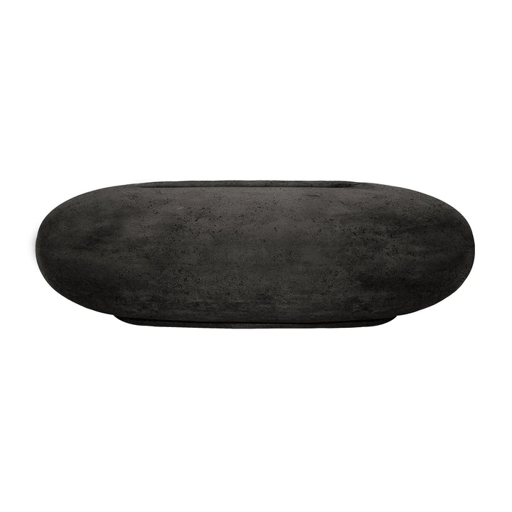 This Prism Hardscapes Pebble Gas Fire Pit in ebony features a smooth, dark concrete finish and an oval shape that complements modern outdoor settings. The propane fire pit design provides both aesthetic value and practical functionality for outdoor heating and ambiance.