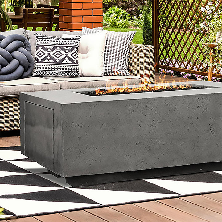 The Prism Hardscapes Portos 68 Propane Fire Table displayed on a modern outdoor deck, featuring a sleek design and flickering flames. Surrounded by outdoor furniture, this fire pit is perfect for backyard gatherings, providing both function and a modern aesthetic for outdoor living spaces.