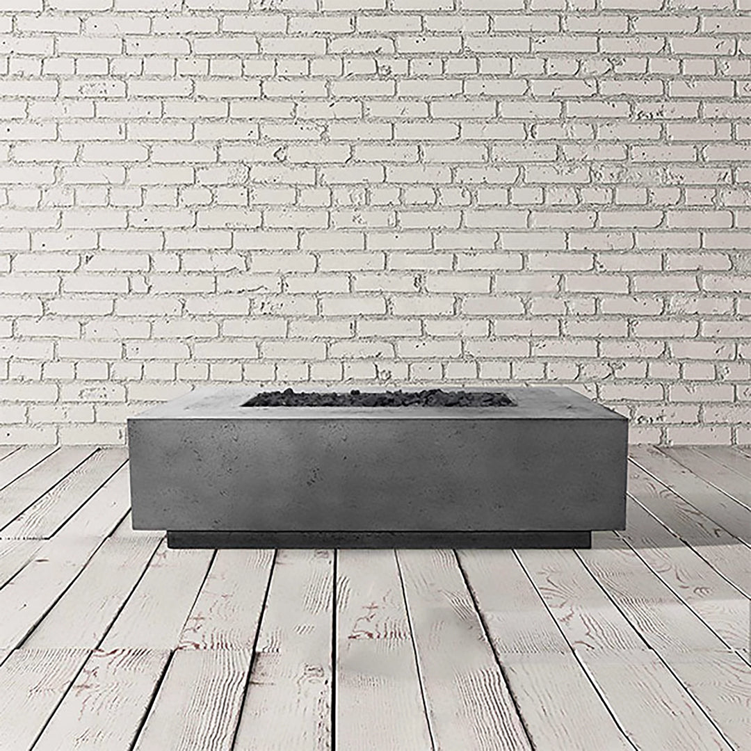 Prism Hardscapes Tavola 1 Gas Fire Pit in a natural grey finish, presented in a sleek studio setting. The rectangular fire pit offers a blend of simplicity and durability, crafted from concrete with a natural, neutral tone. Ideal for any backyard or patio, the gas-powered fire pit delivers warmth and ambiance for outdoor gatherings. Its natural grey color makes it versatile for various decor styles. 