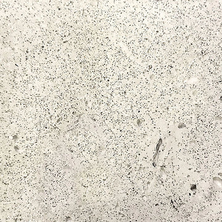 Close-up swatch of the Prism Hardscapes Tavola 1 Gas Fire Pit in a natural gray color, featuring a lightly speckled, weathered texture. This versatile and timeless shade is perfect for outdoor fire pits, enhancing any backyard or patio space with a modern yet rustic look. Ideal for fire pit tables and concrete fire pits