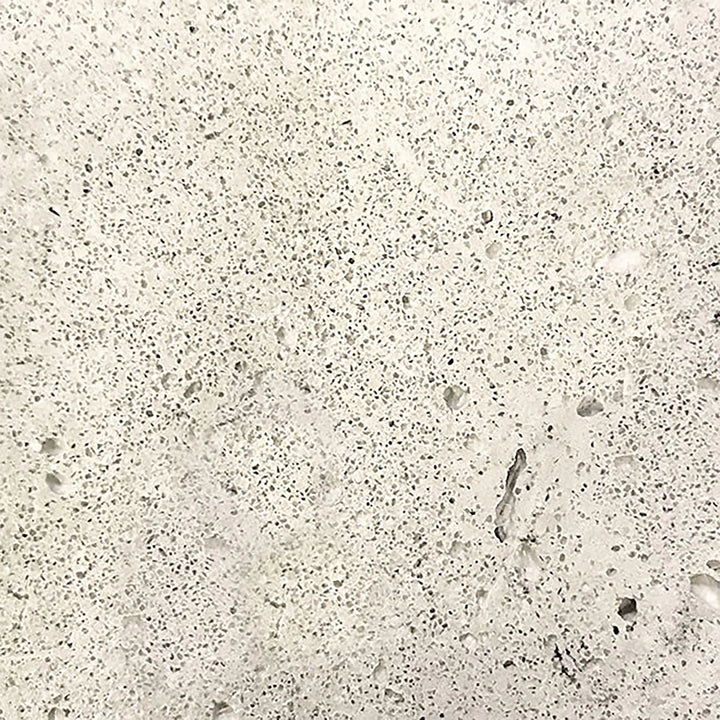 A detailed swatch of the Prism Hardscapes Tavola 3 Gas Fire Pit in natural gray. The light gray concrete texture showcases its raw, unpolished appearance, giving a natural, timeless look that blends seamlessly with outdoor environments. Perfect for fire pits in residential or commercial spaces, offering a neutral, versatile color option.