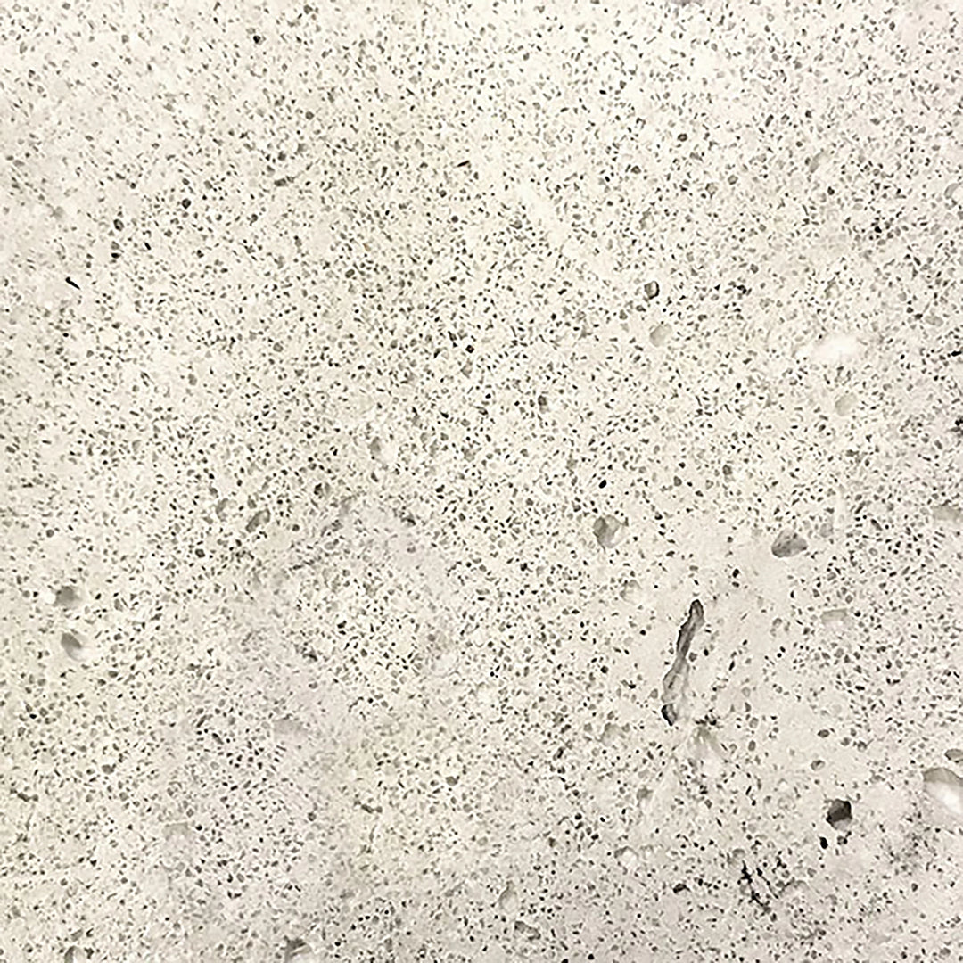 A close-up image of the Prism Hardscapes Tavola 42 Gas Fire Pit swatch in natural gray. The speckled texture of the concrete features a light, neutral tone, making it a versatile choice for any outdoor space. This finish pairs well with various backyard fire pits, offering both durability and style in a natural aesthetic.