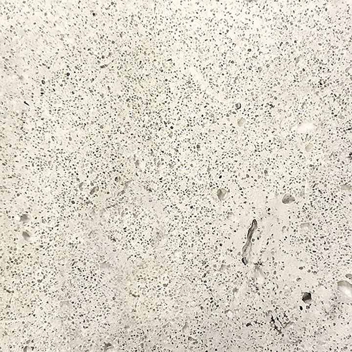 A close-up image of the Prism Hardscapes Tavola 42 Gas Fire Pit swatch in natural gray. The speckled texture of the concrete features a light, neutral tone, making it a versatile choice for any outdoor space. This finish pairs well with various backyard fire pits, offering both durability and style in a natural aesthetic.