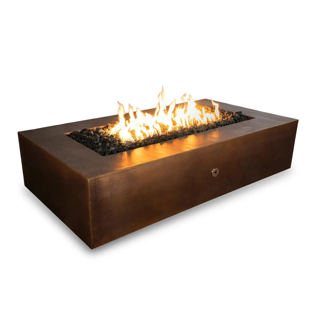 Gravity Moreno 72x38 rectangular copper fire pit by Starfire Designs, featuring a large open flame area with black lava rocks, offering a luxurious outdoor heating solution