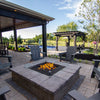 Outdoor setting featuring a stylish rectangular fire pit with the HPC Fire Glass Wind Guard, surrounded by cozy patio chairs and a picturesque backyard landscape. The wind guard helps protect the flame while providing a clear view of the fire. Ideal for enhancing outdoor ambiance with safety and modern aesthetics.