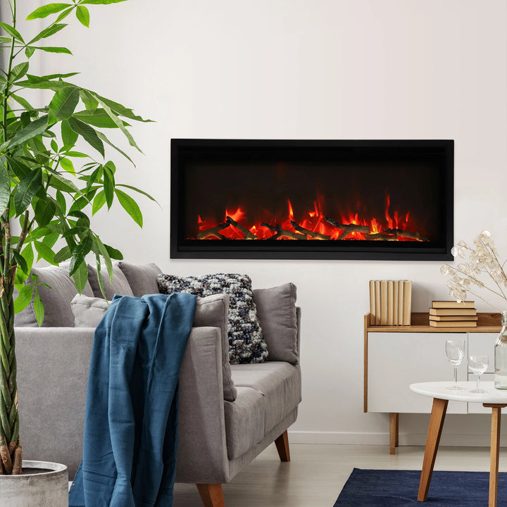 The Remii Indoor Extra Slim Electric Fireplace installed in a cozy living room, emitting realistic red and orange flames with glowing log media. This sleek built-in fireplace integrates seamlessly with the décor, offering energy efficiency and modern design for indoor spaces. A perfect focal point for contemporary homes.