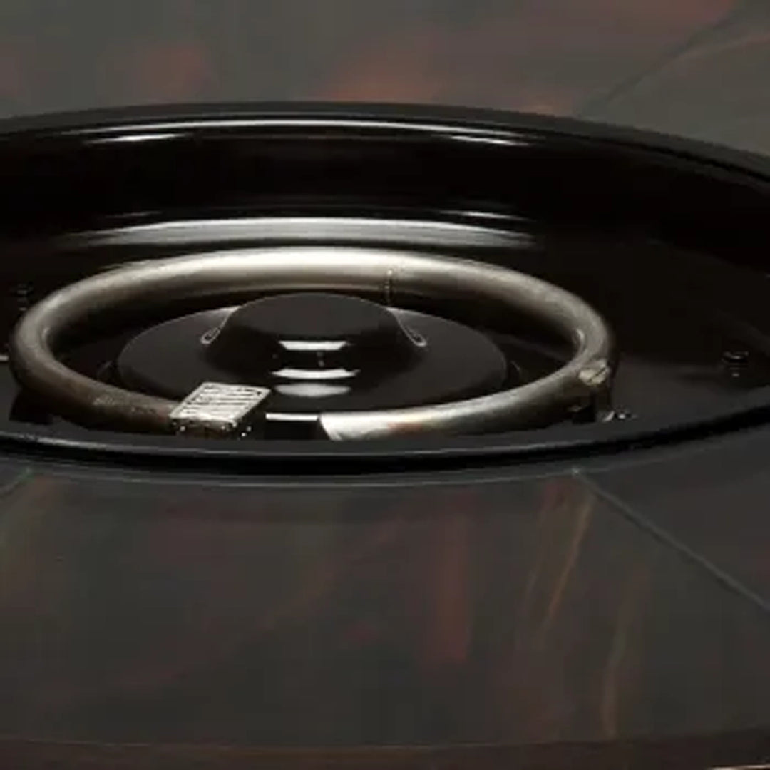 Close-up view of a fire pit burner ring, showcasing the central metal component where flames are produced, set within a polished fire pit structure