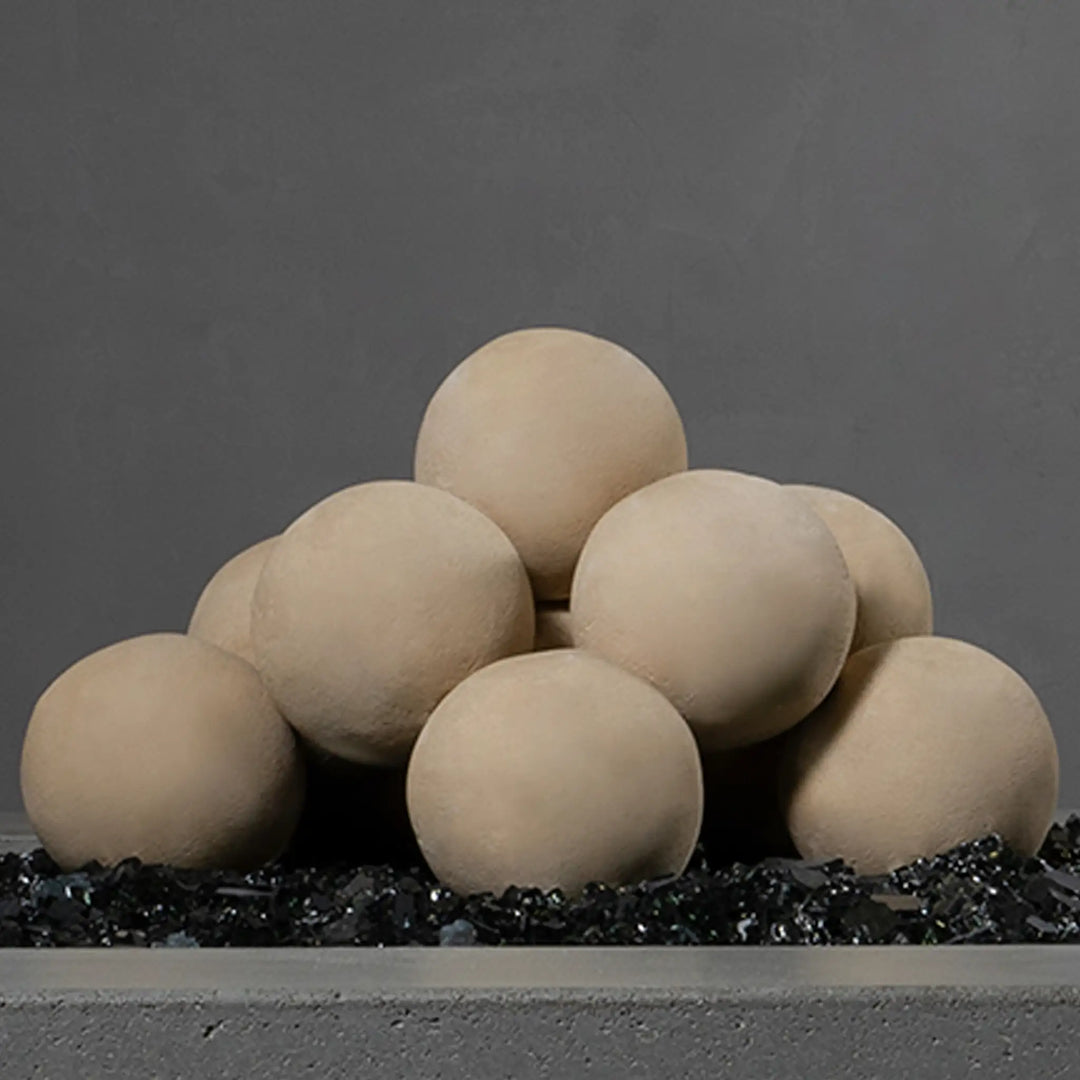 Detailed close-up of beige Starfire Designs 4-inch ceramic fire balls arranged in a geometric stack. The image highlights the texture and uniformity of the spheres, perfect for creating a clean and modern look in fire pits. These durable ceramic balls are heat-resistant and designed for use in fire features, adding elegance to outdoor spaces