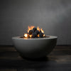 Starfire Designs 4-inch ceramic fire balls set of 12 in dark gray arranged on a round fire pit with dancing flames among the dark fire glass, creating a striking contrast and offering a modern aesthetic to outdoor spaces