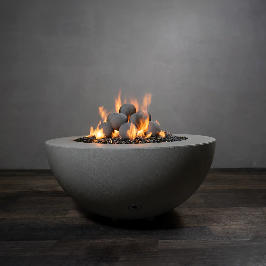 A stunning set of 12 light gray Starfire Designs ceramic fire balls arranged in a round concrete fire pit, with bright orange flames creating a warm and welcoming atmosphere. These fire balls are ideal for enhancing the elegance of fire pits while providing high-temperature durability for safe and stylish fire features