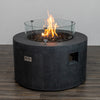 Starfire Designs Beton 42-inch Graphite Round Concrete Gas Fire Pit fitted with a glass wind guard to protect the flame from wind and enhance safety. The sleek design maintains visibility of the vibrant fire feature, making it a focal point for any patio.