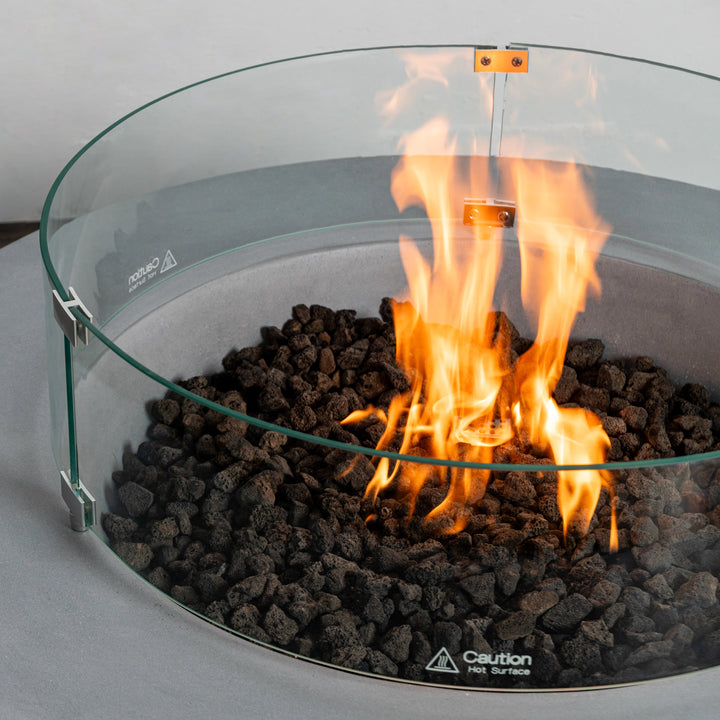 Close-up of the vibrant flame and lava rocks in the Starfire Designs Beton 42 Inch Natural Gray Round Concrete Natural Gas Fire Pit with Push Button Ignition, emphasizing its modern design and functionality for outdoor fire pits.