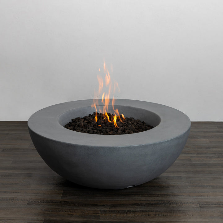 The Starfire Designs Beton 42 Inch Natural Gray Round Concrete Natural Gas Fire Pit with Push Button Ignition, displayed with a vibrant flame, perfect for creating a warm and inviting atmosphere in outdoor fire pits