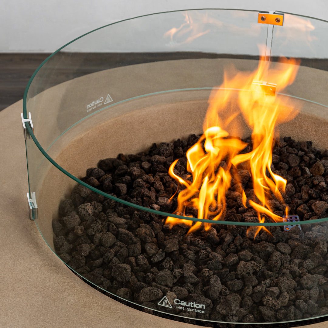 Close-up of the glass wind guard on the Starfire Designs Beton 42 Inch Sand Round Concrete Natural Gas Fire Pit. The flame-resistant glass protects the flames while adding a sophisticated touch to the fire pit design. Suitable for luxury outdoor fire pits and modern aesthetics.