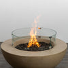 A vibrant display of the Starfire Designs Beton 42 Inch Sand Round Concrete Natural Gas Fire Pit featuring a glass flame guard and robust flames. This modern outdoor fire pit is designed for safety, luxury, and exceptional heat output.