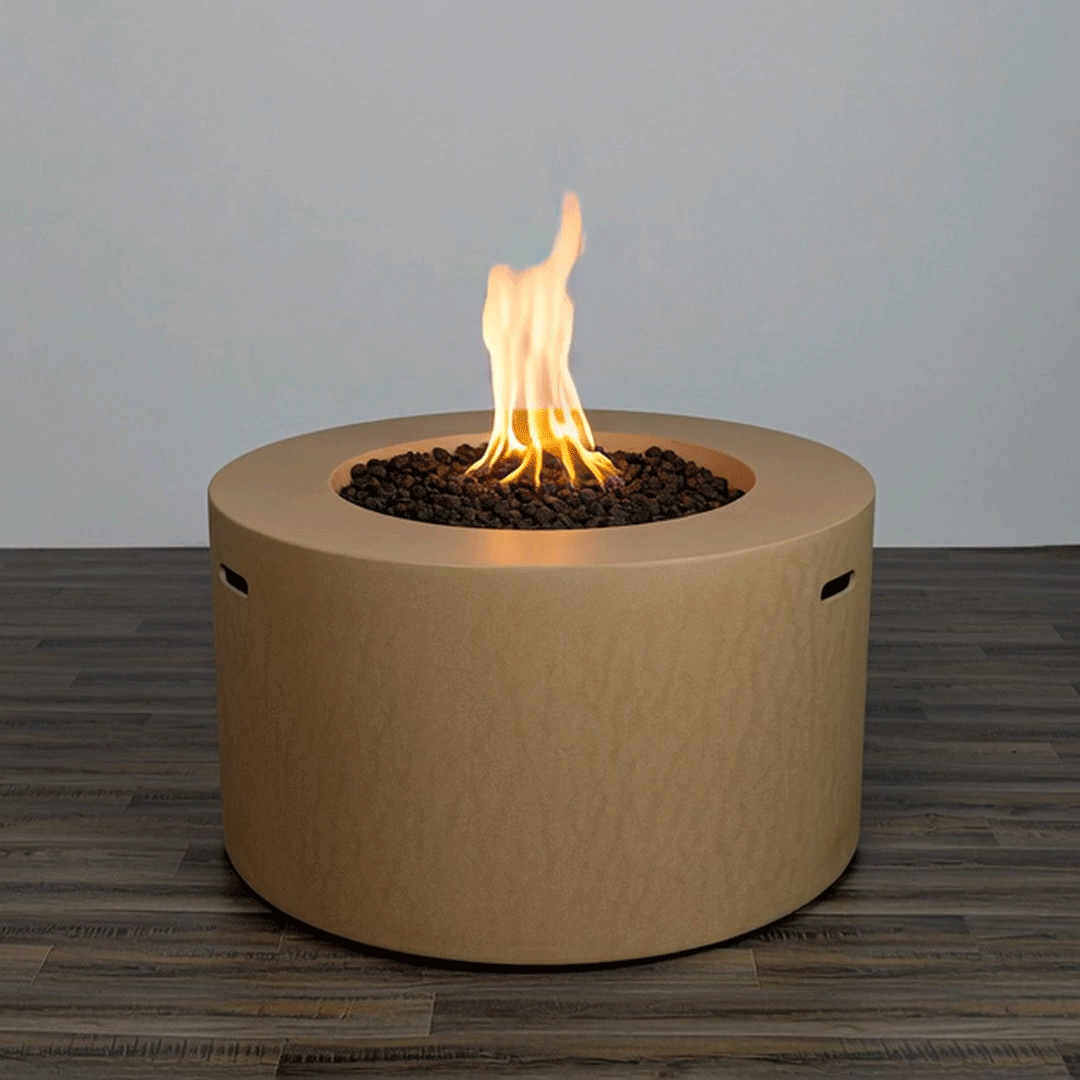 A tall, steady flame dances above dark lava rocks in a sand-colored round concrete fire pit, its smooth modern silhouette standing alone on a wood-look patio surface and emphasizing the clean lines of this gas fire pit design that brings sculptural warmth to contemporary outdoor spaces, with the minimalist modern fire pit serving as a versatile centerpiece ready to anchor cozy seating, soft lighting, relaxed evenings outdoors, and year-round gatherings.