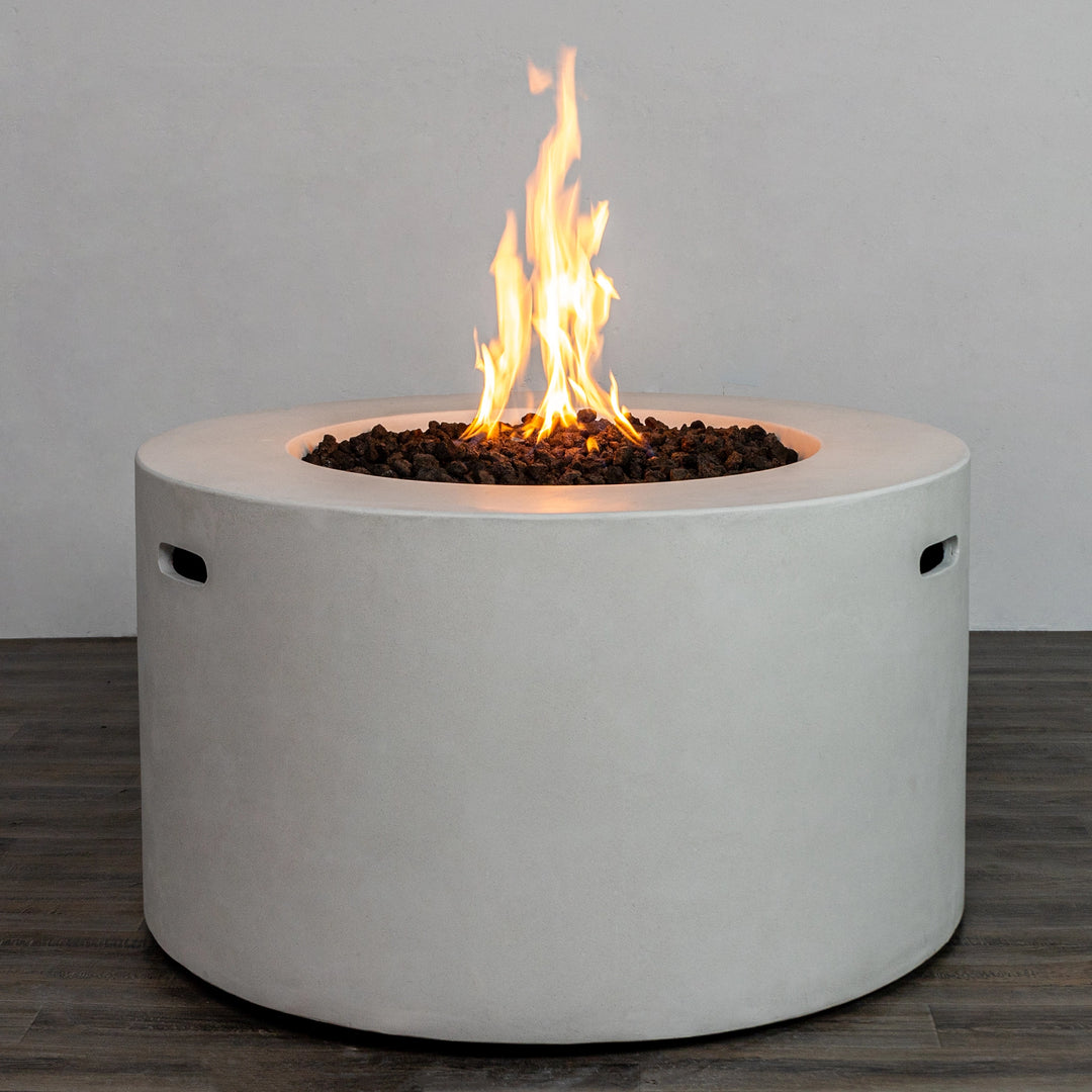 The Starfire Designs Beton 42" White Round Concrete Gas Fire Pit with a strong, glowing flame over the lava rock bed. The white concrete finish contrasts beautifully with the vivid fire, creating a cozy outdoor ambiance.