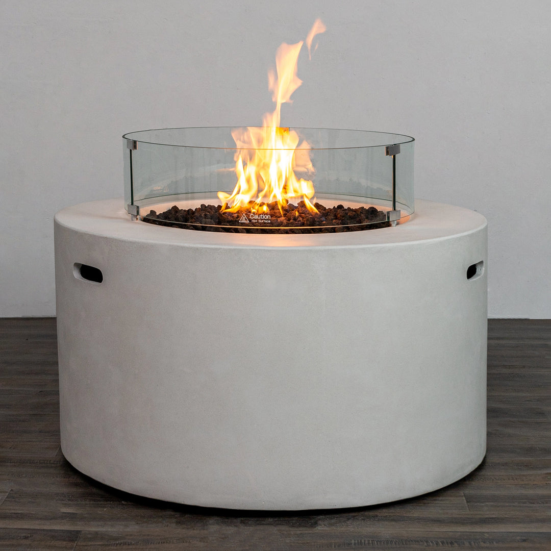 The Starfire Designs Beton 42" White Round Concrete Gas Fire Pit with a circular glass wind guard installed. This accessory enhances safety and flame stability, making it ideal for outdoor patio fire pit gatherings, even in breezy conditions.