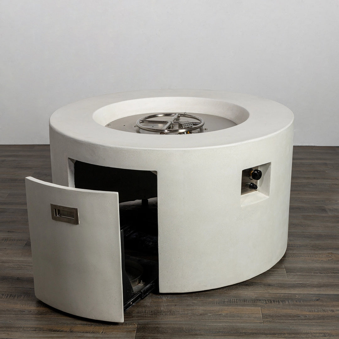 The Starfire Designs Beton 42" White Round Concrete Gas Fire Pit showcasing an open access door with a hidden compartment for the propane tank. This outdoor gas fire pit design combines convenience and style, making it a modern outdoor patio centerpiece.