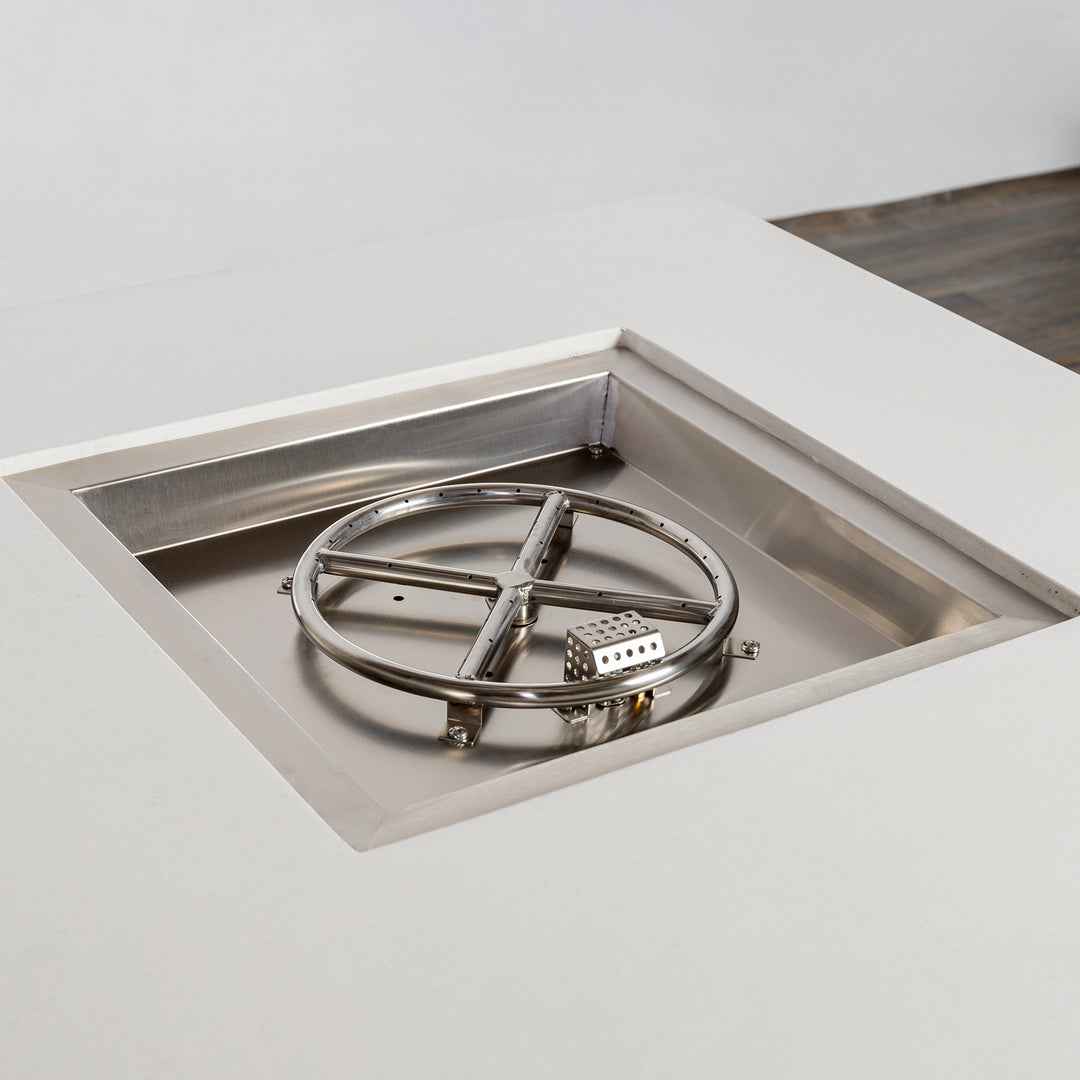 A close-up view of the stainless steel burner inside the Starfire Designs Beton 42" White Square Hidden Propane Tank Gas Fire Pit, highlighting the durable circular burner and clean recessed design for even flame distribution.