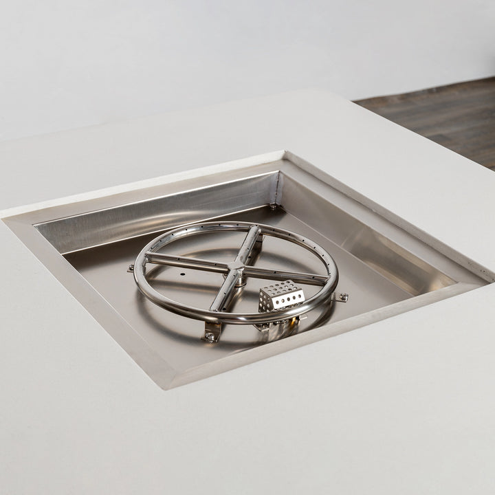 A close-up view of the stainless steel burner inside the Starfire Designs Beton 42" White Square Hidden Propane Tank Gas Fire Pit, highlighting the durable circular burner and clean recessed design for even flame distribution.