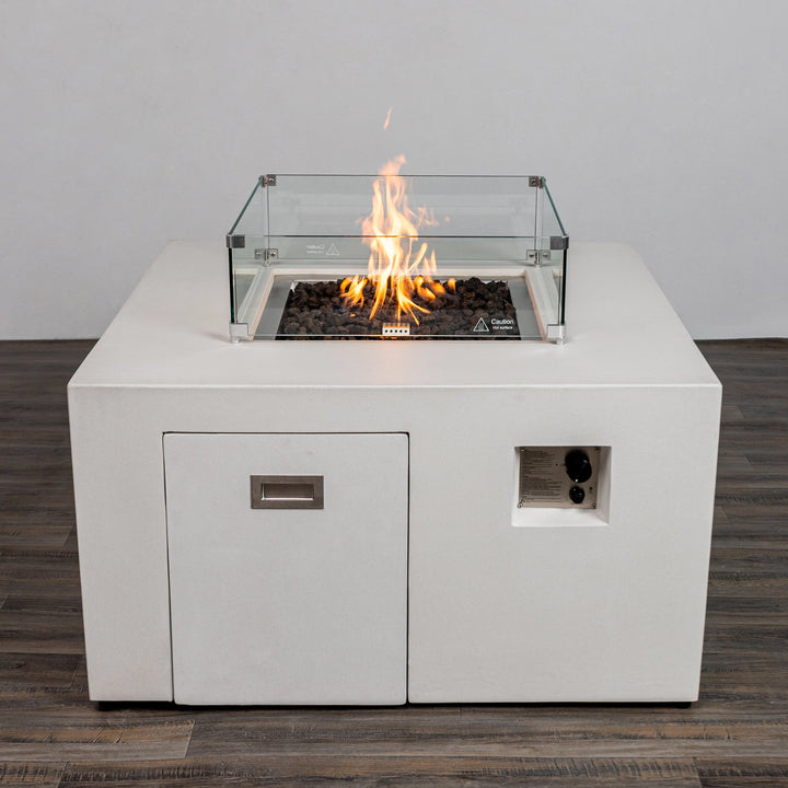 The Starfire Designs Beton 42" White Square Hidden Propane Tank Gas Fire Pit with an optional glass wind guard installed, providing safety and flame stability in breezy conditions.