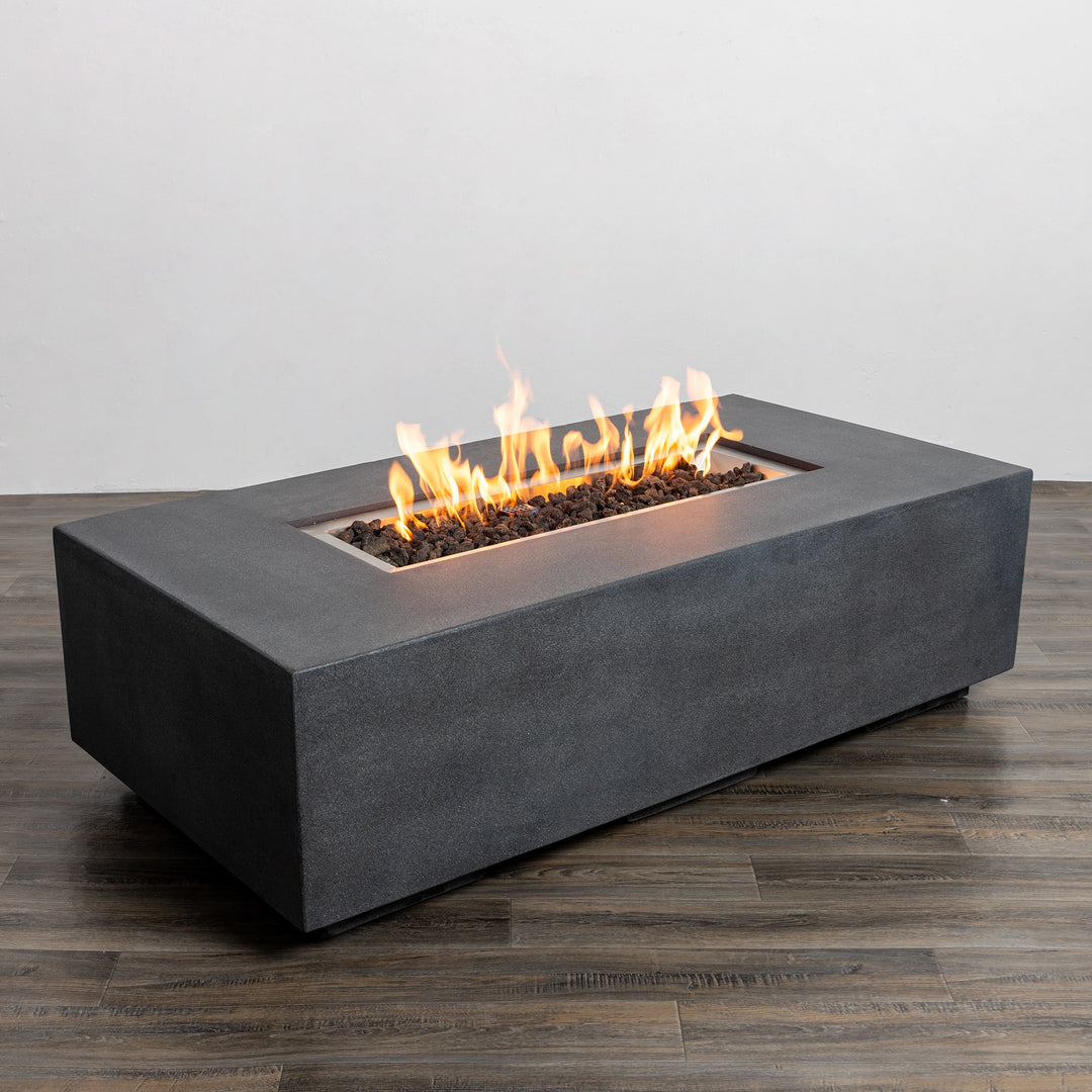 Angled view of the Starfire Designs Beton 55" Graphite Rectangle Gas Fire Pit with active flames, showcasing its sleek edges and smooth graphite finish, perfect for modern outdoor aesthetics.