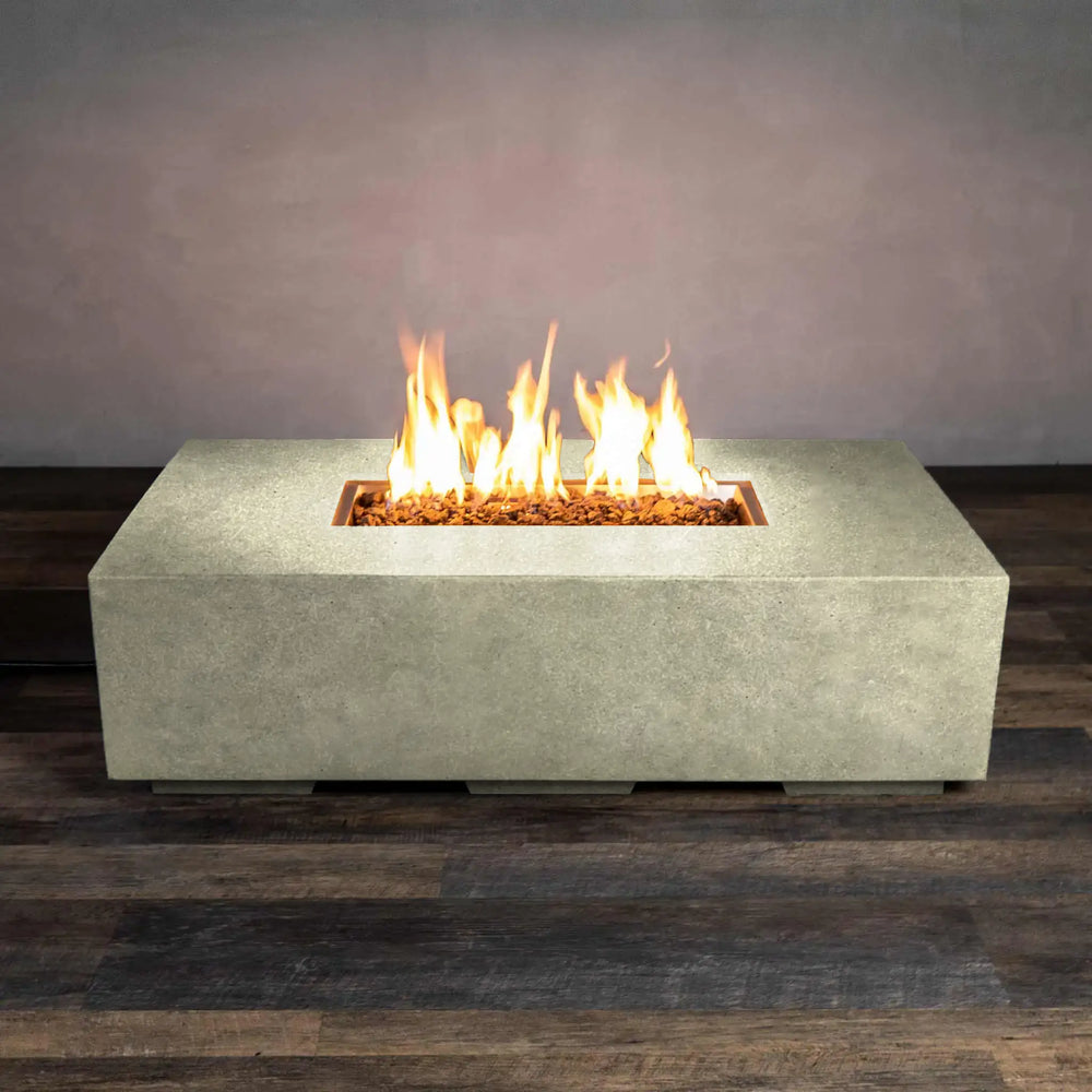 Side-lit view of the Starfire Designs Beton 55-inch rectangle gas fire pit in sand, displaying its sleek design and flickering flames