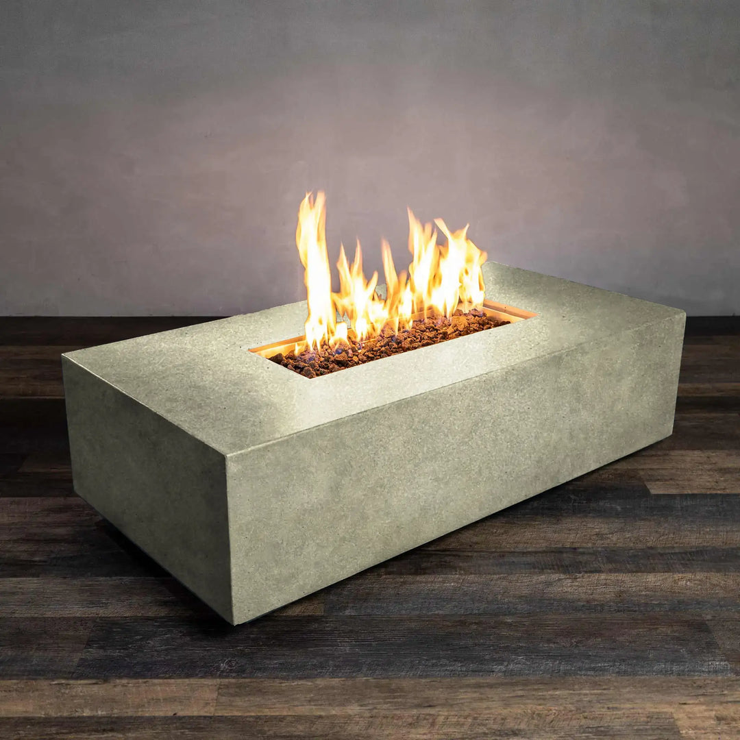 Front-lit view of the Starfire Designs Beton 55-inch rectangle gas fire pit in sand, featuring natural flames over a bed of lava rocks