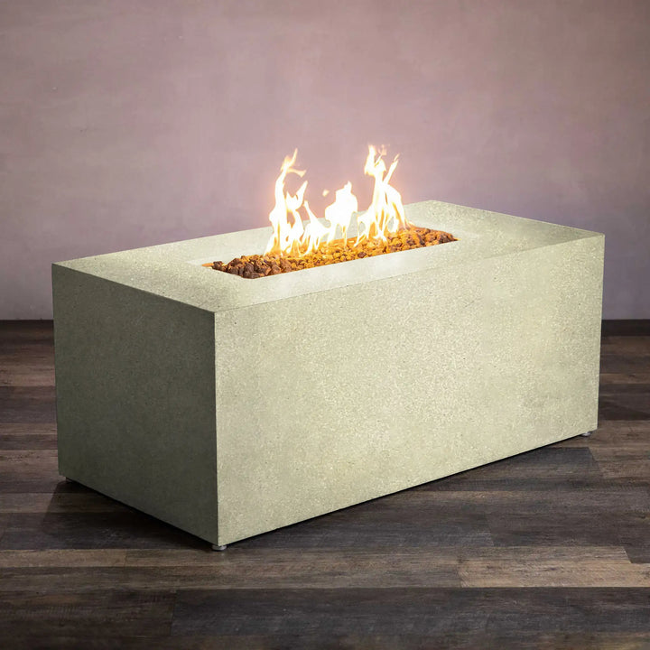 Lit view of the Starfire Designs Beton 55-inch rectangle hidden propane tank fire pit in sand finish, demonstrating the warm and inviting flame surrounded by lava rocks