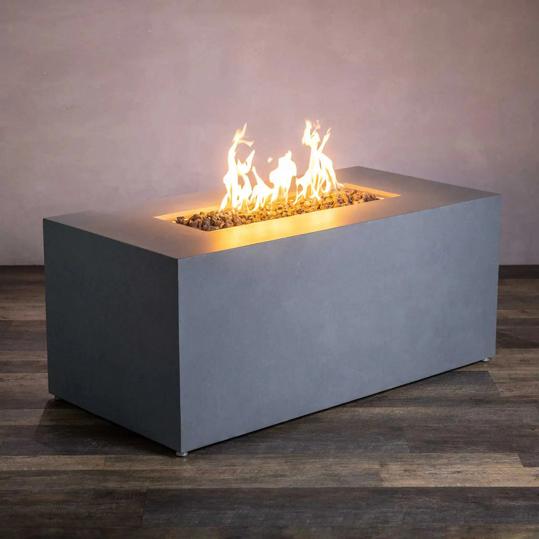 Angled view of the Starfire Designs Beton 55" natural gray rectangle gas fire pit with hidden propane tank, showcasing warm flames for an inviting outdoor space