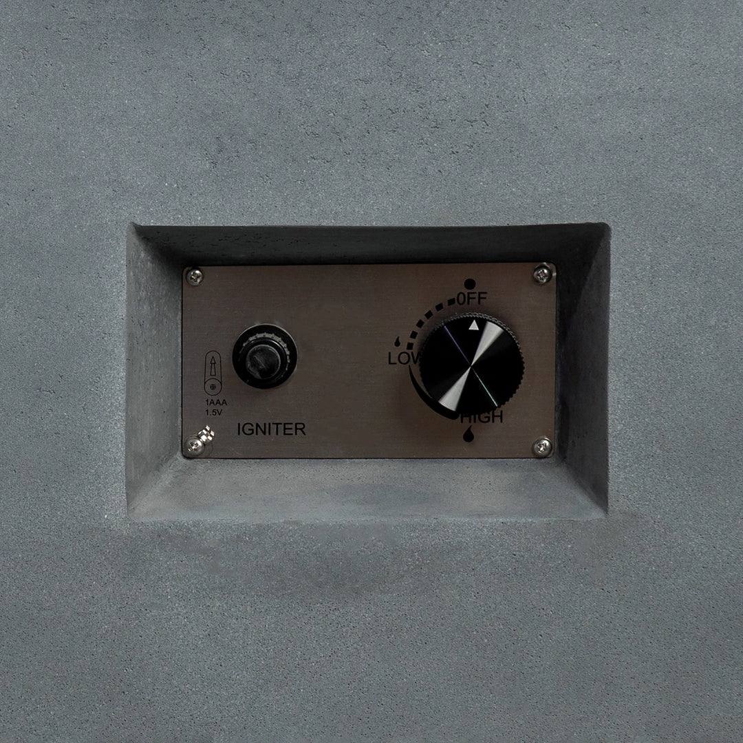 Close-up of the control panel on the Starfire Designs Beton 55-inch natural gray rectangle gas fire pit, showing the stainless steel igniter button and flame control knob for adjusting flame height. This panel is seamlessly embedded in the concrete design for easy operation.