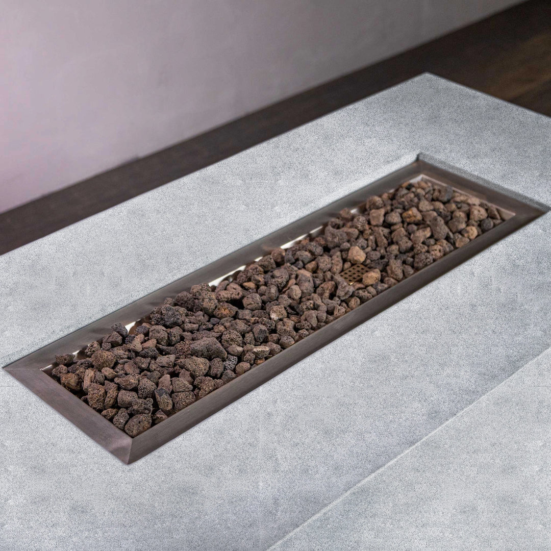 Starfire Designs Beton 55-inch natural gray rectangle hidden propane tank gas fire pit with lava rocks viewed from above. The top-down angle captures the elegant concrete surface and premium lava rock bed, highlighting its simple yet sophisticated design for outdoor patios.