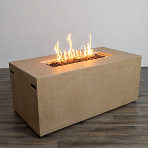 Angled view of the Starfire Designs Beton 55" Sand Rectangle Hidden Propane Tank Gas Fire Pit with flames dancing over the burner. The sand-colored concrete finish adds warmth and style to any backyard or outdoor patio area.