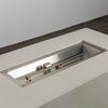 Close-up of the stainless steel burner inside the Starfire Designs Beton 55" White Rectangle Gas Fire Pit. The linear burner is surrounded by a recessed pan, offering precision-engineered performance for efficient flame distribution.