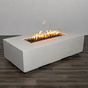 Side view of the Starfire Designs Beton 55" White Rectangle Gas Fire Pit with flames burning over black lava rocks. The long, rectangular burner creates a stunning linear fire effect, enhancing any outdoor ambiance. 