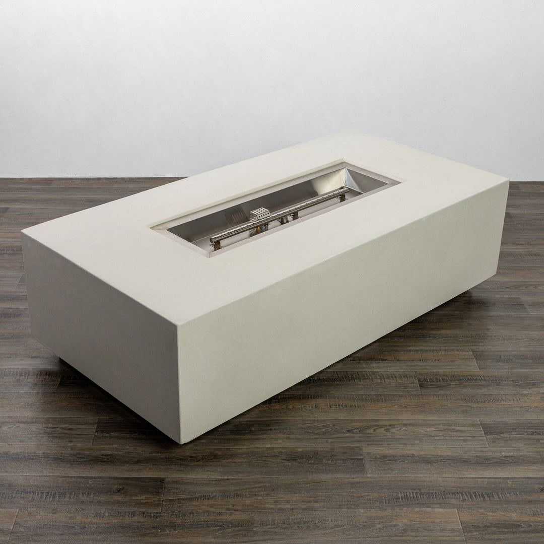 Full side view of the Starfire Designs Beton 55" White Rectangle Gas Fire Pit, showcasing the clean rectangular profile with a smooth white GFRC concrete surface. The fire pit is placed on a dark wood floor, highlighting its modern and contemporary design.