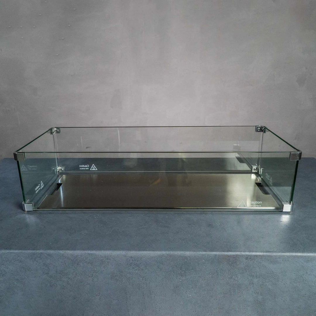 Starfire Designs Beton Rectangle Glass Wind Guard placed on a gas fire pit, offering protection against wind while maintaining a clear view of the flames