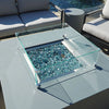 Overhead shot of Starfire Designs Beton Square Glass Wind Guard. Tempered glass panels encase decorative blue fire glass, enhancing modern fire table aesthetics for contemporary outdoor spaces