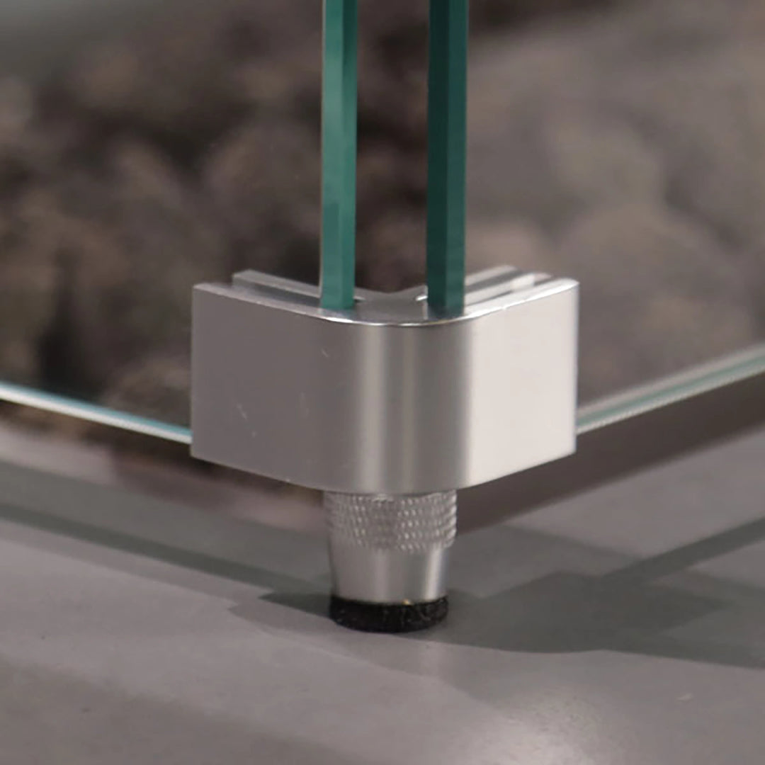 Detailed view of the Starfire Designs Beton Square Glass Wind Guard silver bracket. Secure connection between tempered glass panels provides durability and safety, creating a refined finish for outdoor fire features.