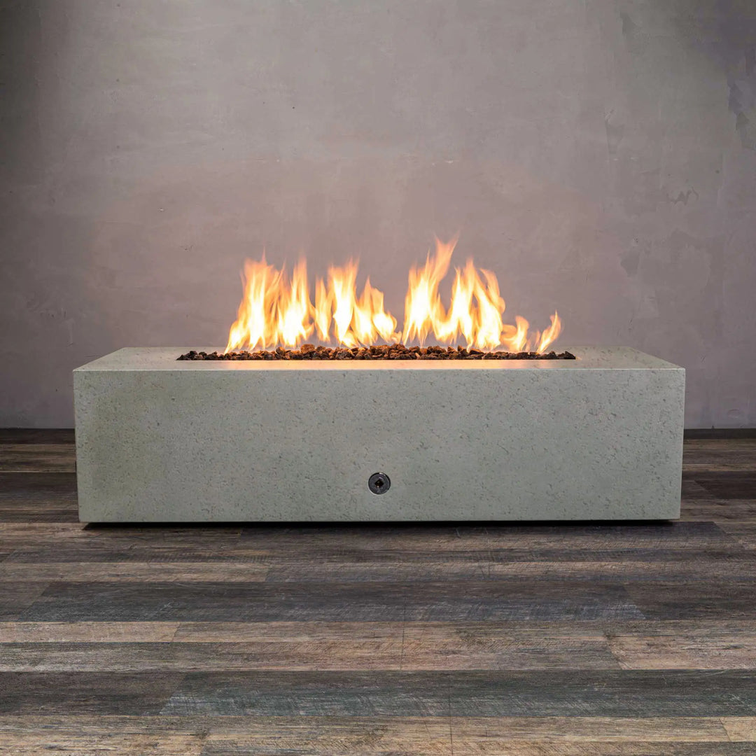 A beige concrete rustic 60"x24" linear gravity gas fire pit with flames, perfect for outdoor spaces. Keywords: outdoor fire pit, natural gas fire pit, large fire pits, fire bowl outdoor, modern fire pit