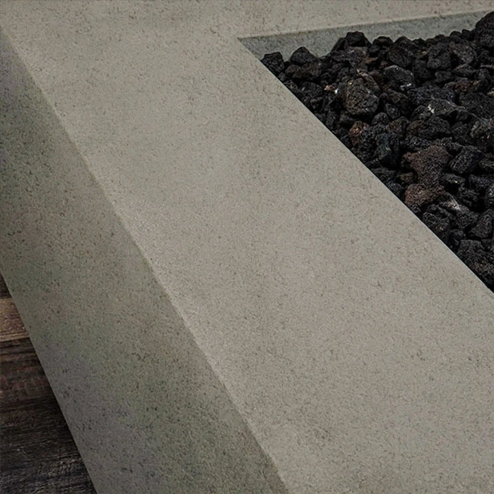  Detail of the edge and lava rocks of the beige concrete 60"x24" linear gas fire pit. Keywords: luxury fire pits, fire pit for backyard, modern fire pit, outdoor fire pit with cover, fire pit outdoor.