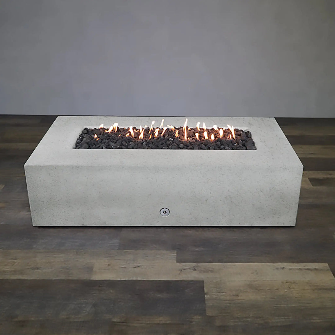 Full view of the Starfire Designs Concrete Rustic 60-inch by 32-inch Rectangle Gravity Gas Fire Pit in White, offering a complete look at the rectangular fire pit with burning lava rocks. This gas fire pit is designed for luxury outdoor environments, providing both warmth and a stylish centerpiece for gatherings