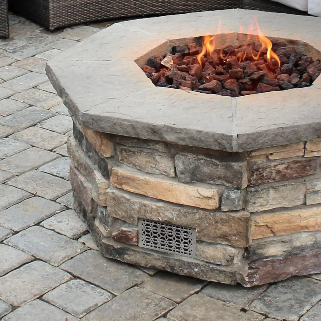 Lifestyle image of the Starfire Designs Decorative Fire Pit Venting Panel - Arbor installed in a stone outdoor fire pit. The arbor-patterned venting panel enhances both the safety and design of this backyard fire pit setup